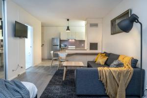 a living room with a couch and a kitchen at 'Zen Boutique' A Well-connected Studio with Parking in Sydney