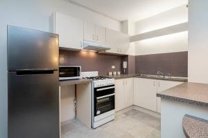 シドニーにある'Zen Boutique' A Well-connected Studio with Parkingのキッチン(ステンレス製の冷蔵庫、白いキャビネット付) +6枚の写真