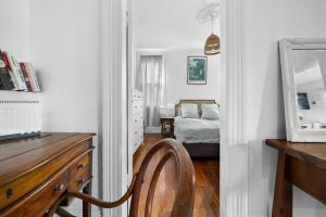 ein Schlafzimmer mit einem Bett, einem Spiegel und einem Stuhl in der Unterkunft Pocket of Petersham - A Stylish Inner-West Retreat in Sydney