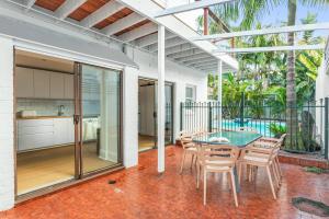 a patio with a table and chairs and a kitchen at Henrietta - Poolside Relaxation near Bronte Beach in Sydney