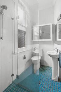 a bathroom with a shower and a toilet and a sink at Pocket of Petersham - A Stylish Inner-West Retreat in Sydney