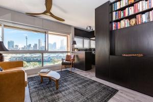 a living room with a couch and a book shelf at Best Sydney Views from Potts Point with Rooftop Pool in Sydney