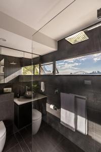 a bathroom with a toilet and a sink and a mirror at Best Sydney Views from Potts Point with Rooftop Pool in Sydney