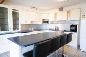 a kitchen with white cabinets and a black counter top at St Helens On The Bay in St Helens