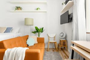 uma sala de estar com um sofá e uma cama em A Cosy Scandi-Style Studio on Bondi Beach em Sidney