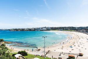 a beach with a lot of people and the ocean at A Cosy Scandi-Style Studio on Bondi Beach in Sydney