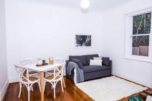 uma sala de estar com um sofá e uma mesa em Courtyard Esperanza - Sunny Heritage Chic em Sydney