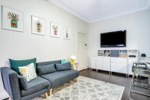 een woonkamer met een bank en een flatscreen-tv bij Coogee Classic - Coastal Gem Close to Beach in Sydney