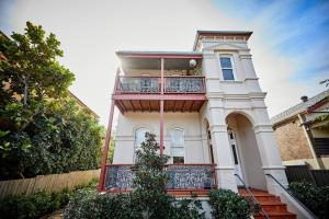 een groot wit huis met een balkon bij Easy Esperanza - Compact Indoor-outdoor Living in Sydney