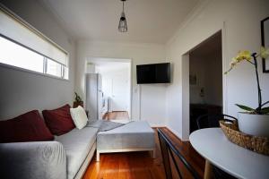 een woonkamer met een bank en een tafel bij Easy Esperanza - Compact Indoor-outdoor Living in Sydney