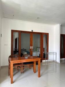 a living room with a wooden table and a bed at Pererenan nengah guest house in Canggu