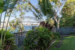 um jardim com a ponte do porto sydney ao fundo em Harbourfront Art Deco Hall - Sought-after in Sydney em Sydney