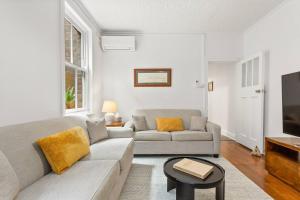 una sala de estar con un sofá y una mesa en Harbourfront meets Heritage Chic near Barangaroo, en Sídney