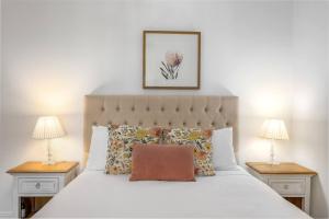 Un dormitorio con una cama blanca con dos mesitas de noche. en Harbourfront meets Heritage Chic near Barangaroo, en Sídney