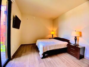 a bedroom with a bed and a dresser with two lamps at TriBeCa San Miguel in San Miguel de Allende