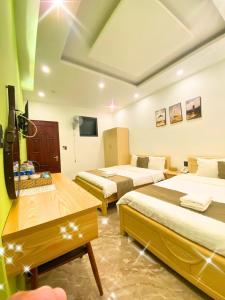 Cette chambre comprend 2 lits et une télévision à écran plat. dans l'établissement Sunrise Valley Dalat Hotel, à Đà Lạt