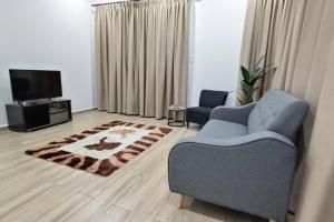 uma sala de estar com um sofá e uma televisão em Tokiku Homestay Paka unit B em Paka