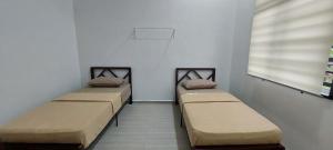 three beds in a room with a window at Tokiku Homestay Paka unit B in Paka