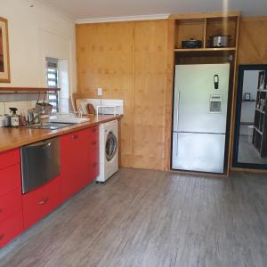 a kitchen with red cabinets and a white refrigerator at Guesthouse in pacific paradise in Pacific Paradise 