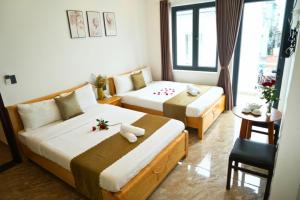 una camera d'albergo con due letti e un tavolo di Sunrise Valley Dalat Hotel a Da Lat