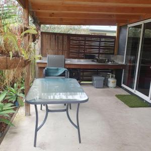 una mesa y una silla en un patio en Guesthouse in pacific paradise, en Pacific Paradise 