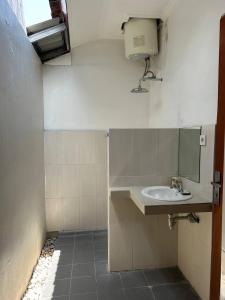 a small bathroom with a sink and a window at Pererenan nengah guest house in Canggu