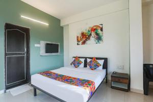 a small bedroom with a bed and a tv at FabHotel Elite Homes in Nagpur