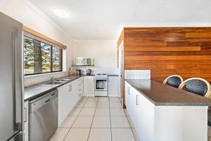 a kitchen with white cabinets and a counter top at Anjuna, 2 bedroom apartment on canal in Mooloolaba