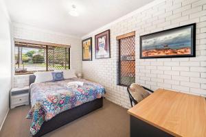 a bedroom with a bed and a table in it at Anjuna, 2 bedroom apartment on canal in Mooloolaba
