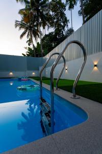 a swimming pool with a metal stairway in a yard at The Vogue - Luxury Private Pool Villa , Athirappilly in Athirappilly