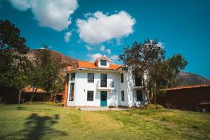 a white house with an orange roof at Beautiful house in the Sacred Valley "Casa Julia Cusco" in Cusco
