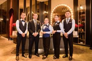 a group of men in tuxedos standing in front of a store at La Seine Hotel in Vientiane