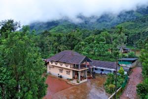 an aerial view of a house in the mountains at Karadikallu Homestay - Private Waterfalls & Guided Trek in Sakleshpur