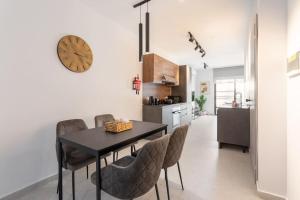 een eetkamer met een tafel en stoelen en een klok bij Sliema Boutique Apartments in Sliema