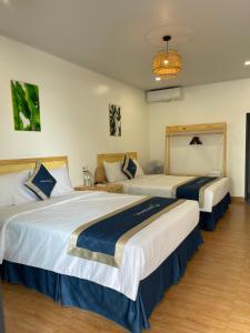 Pokój hotelowy z 2 łóżkami i żyrandolem w obiekcie Woodstock Beach Camp w mieście Cát Bà