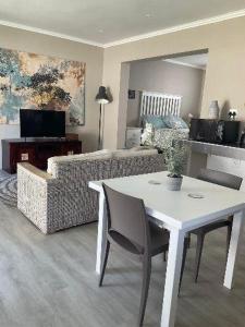 a living room with a table and a couch at Lavender Grove in George