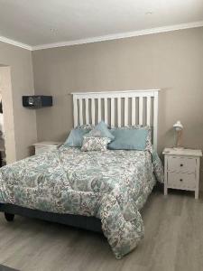 a bedroom with a large bed with blue pillows at Lavender Grove in George