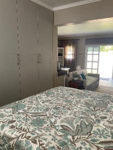 a bedroom with a large bed with a flowered blanket at Lavender Grove in George