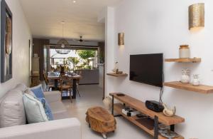 - un salon avec un canapé et une télévision murale dans l'établissement Beach Villa Mauritius, à Roches Noires