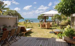un patio con mesa, sillas y el océano en Beach Villa Mauritius, en Roches Noires