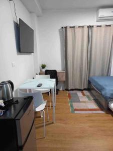 a room with a bed and a table and a kitchen at 6F Balcony View Studio Mesatierra Garden Residences in Davao City