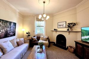 a living room with a couch and a fireplace at Carinya Cottage in Myrtleford