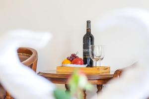 a bottle of wine and a bowl of fruit on a table at Villa Hoa Ly Đà Lạt in Da Lat
