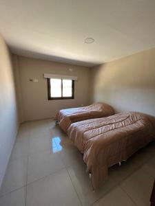 three beds lined up in a room with a window at Greca House in Valle Grande