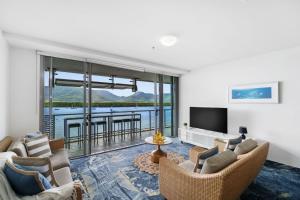 - un salon avec deux canapés et une télévision dans l'établissement Belle Escapes 24 Harbour Lights Water View Apartment, à Cairns