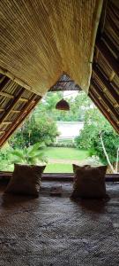 a room with pillows and a view of a golf course at NJ House in Tangalle