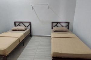 Giường trong phòng chung tại Tokiku Homestay Paka unit A