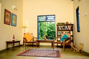 een woonkamer met een tafel en stoelen en een raam bij Palagama Beach Resort in Kalpitiya