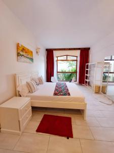 een slaapkamer met een groot wit bed en een raam bij Slique Apartment in Ukunda
