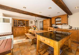 a kitchen with wooden cabinets and a large island at Plas Newydd in Rhiw